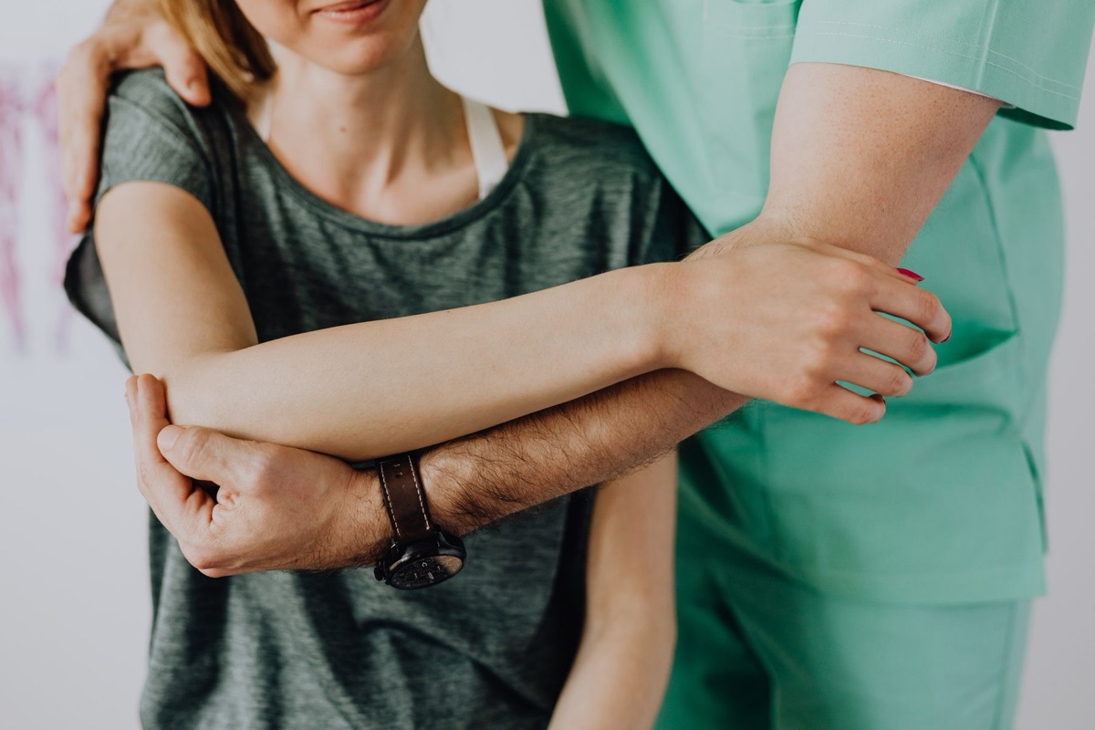 Practitioner performing muscle strength testing on a patient's arm