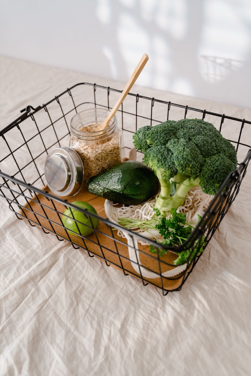 A basket of fresh vegetables, avocado and whole oats